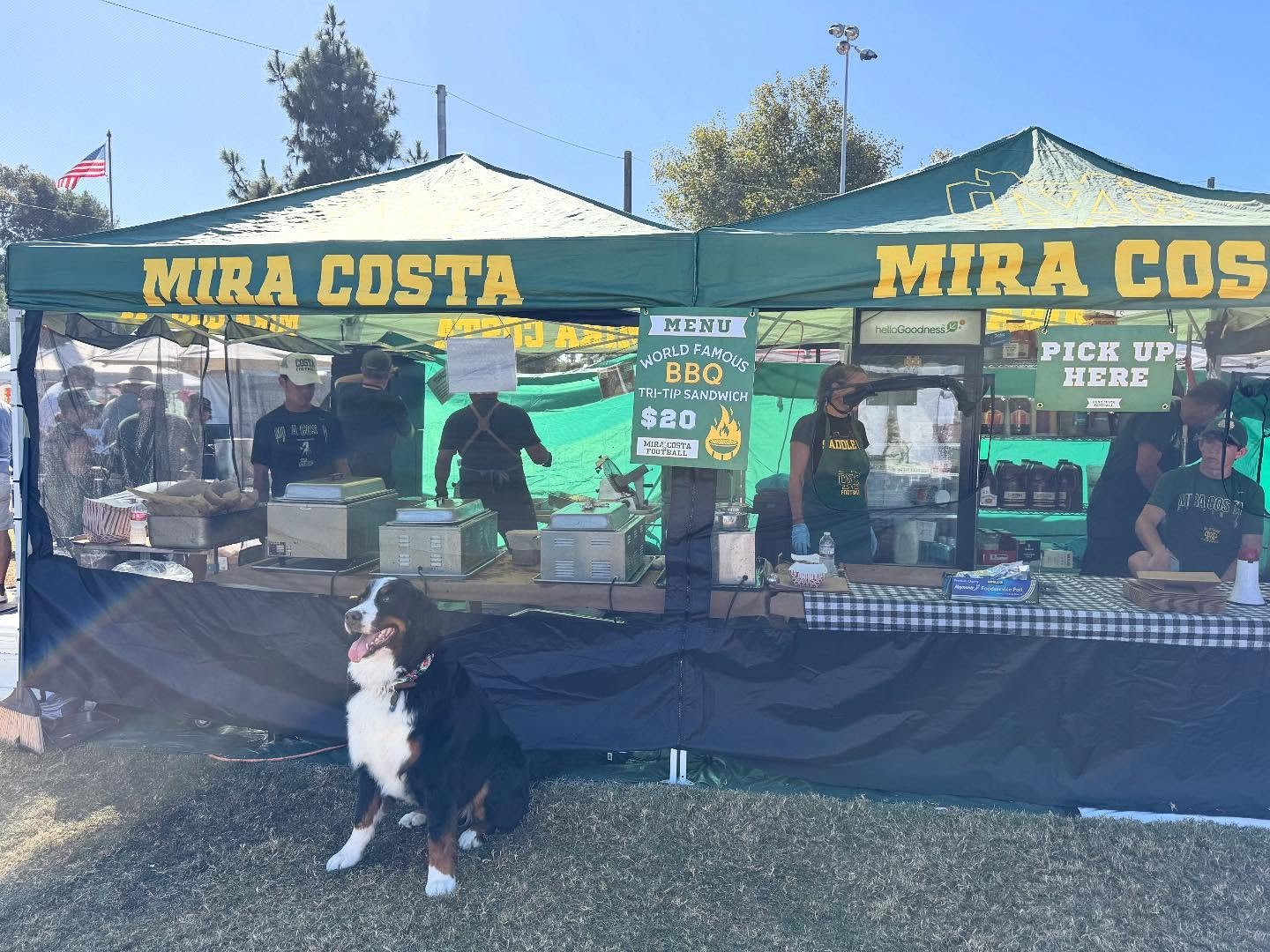 The Mira Costa Tri-Tip Booth at the Manhattan Beach Hometown Fair — green canopies, the $20 tri-tip sandwich menu, and the crew at work